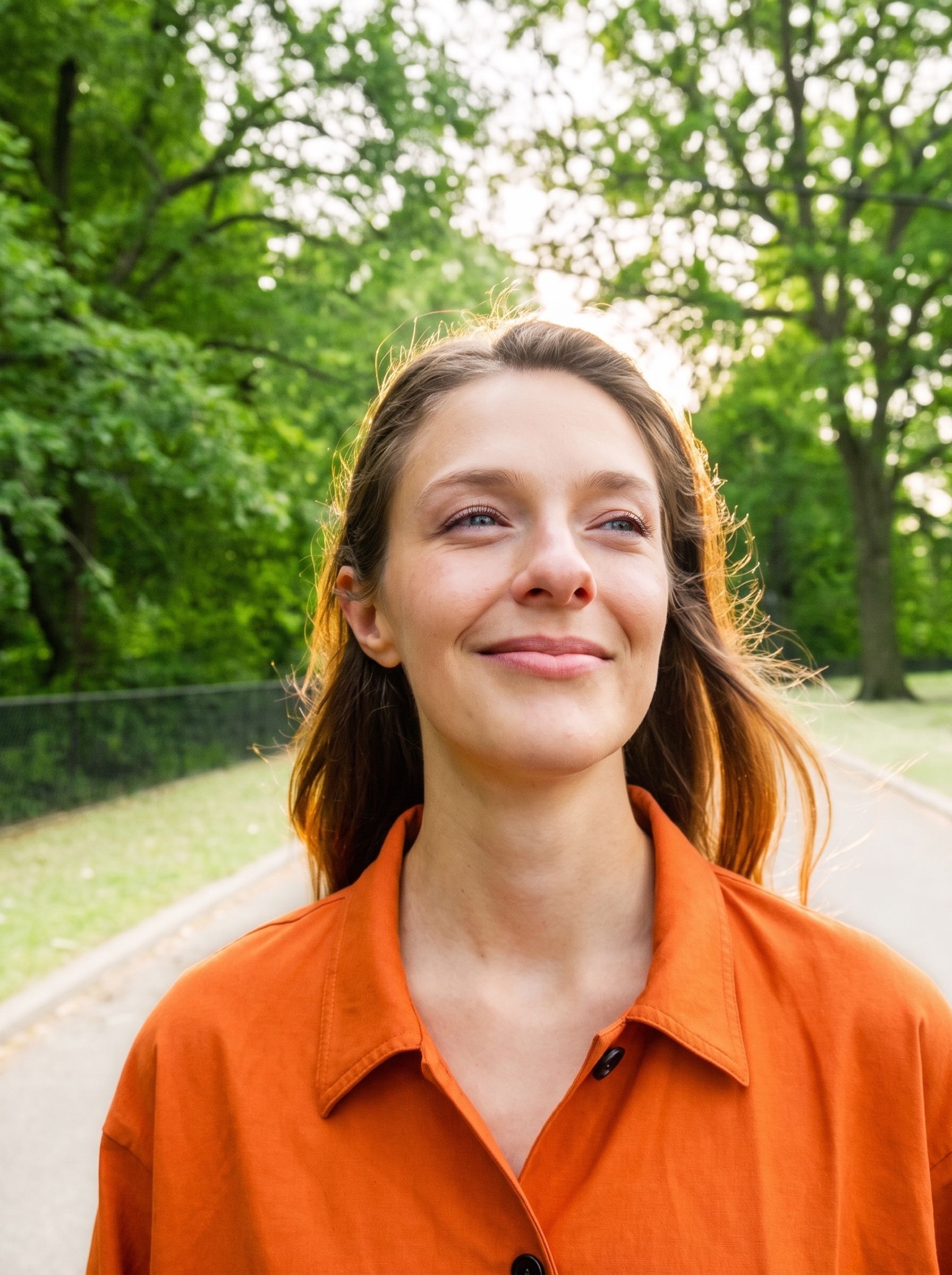 A woman on an unhurried evening walk in the park at golden hour